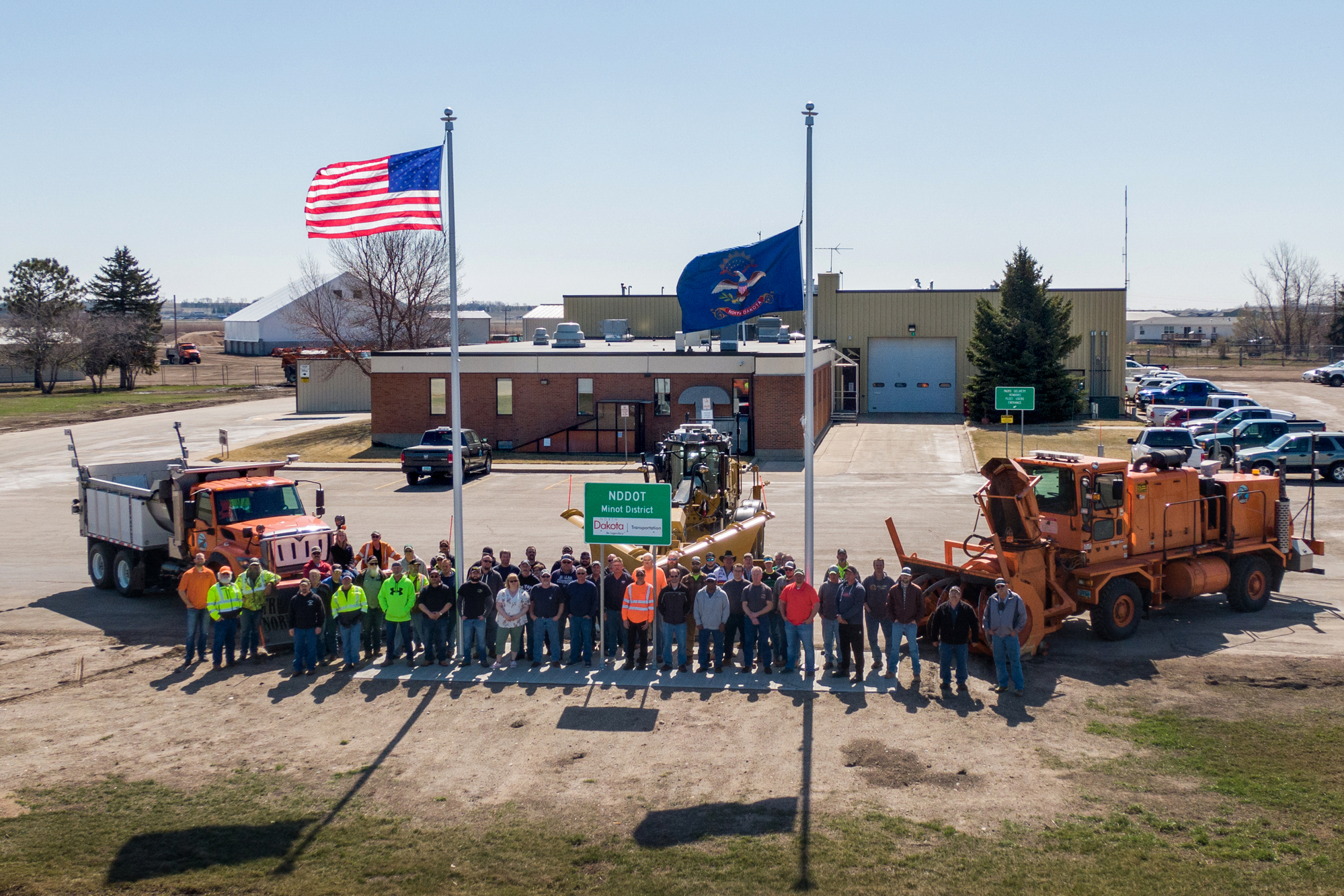 Group photo of Minot District Office employees in front of their buildiing.